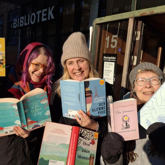 Viser 3 forfrosne biblioteksværter med bøger i hænderne